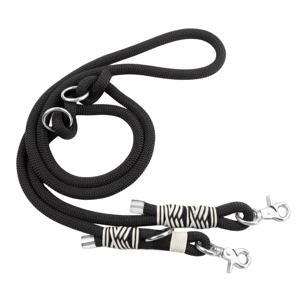 Black dog leash with zebra patterned clips on a white background